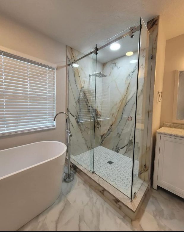 Completed bathroom remodel in Tampa with a frameless glass shower enclosure, large-format porcelain tile walls and a freestanding soaking tub